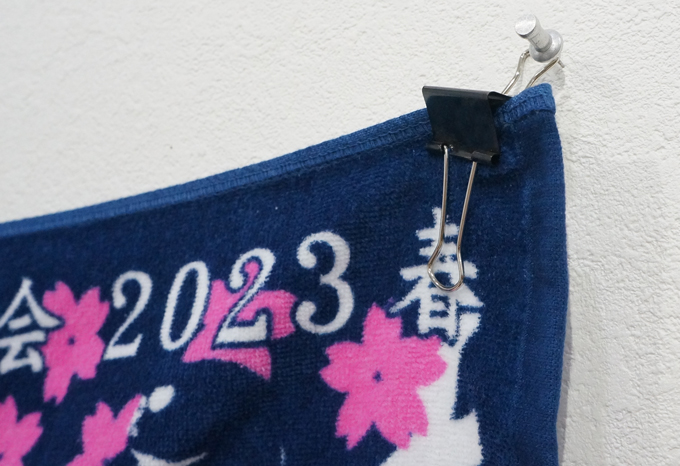 甲子園タオルをクリップで挟み、画鋲にかけている部分の写真です。